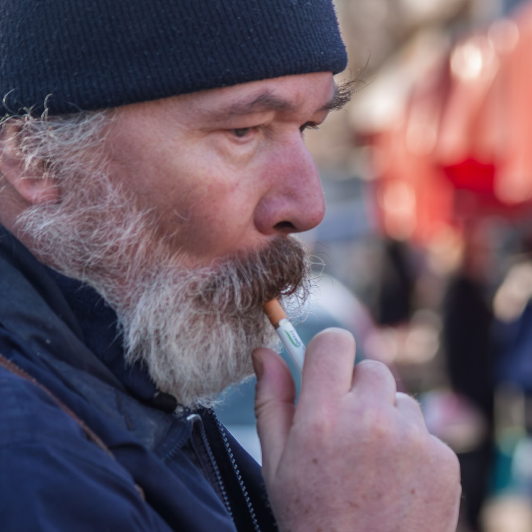 Głowa mężczyzny trzymająca papierosa w ustach. Profesjonalny portret mężczyzny w artystycznym wydaniu.